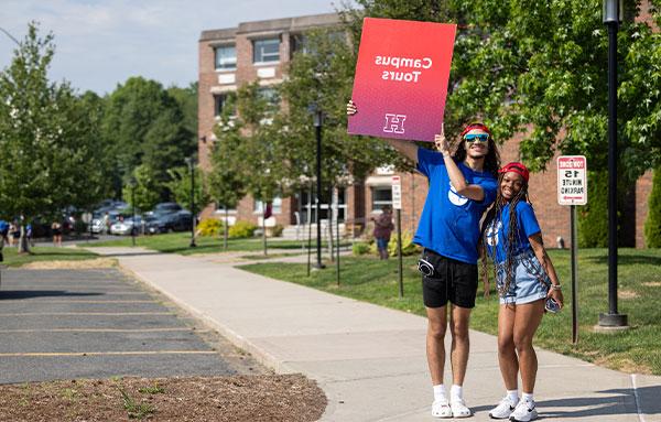 Students with campus tour sign